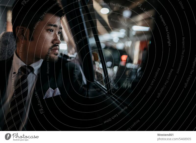 Young businessman in a taxi looking out of window human human being human beings humans person persons Asian Asians Japanese 1 one person only only one person