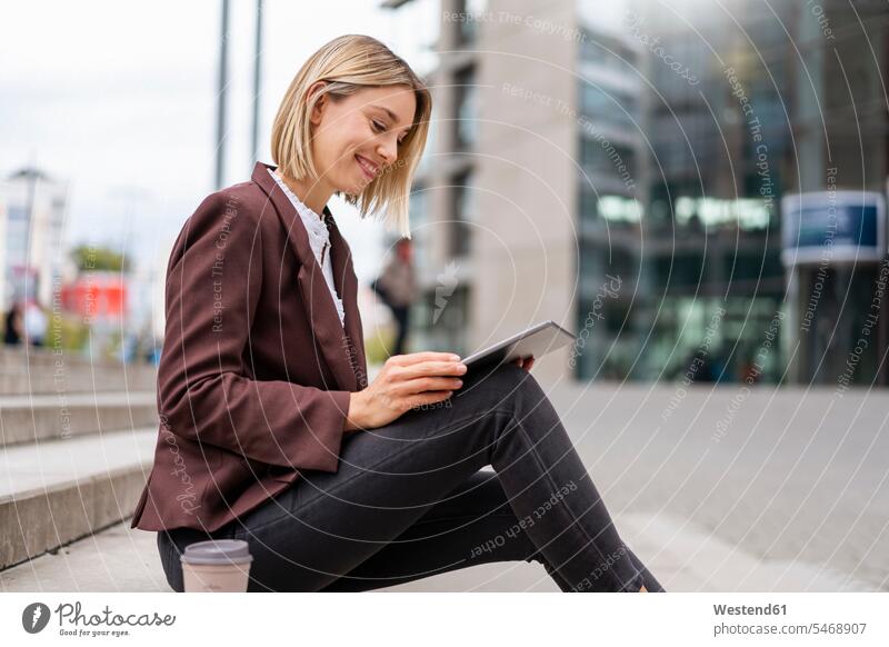 Smiling young businesswoman using tablet in the city human human being human beings humans person persons caucasian appearance caucasian ethnicity european 1