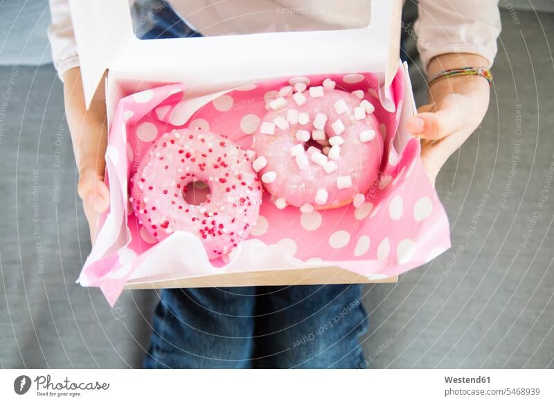Girl holding box with doughnuts, partial view girl females girls boxes donuts Doughnuts child children kid kids people persons human being humans human beings