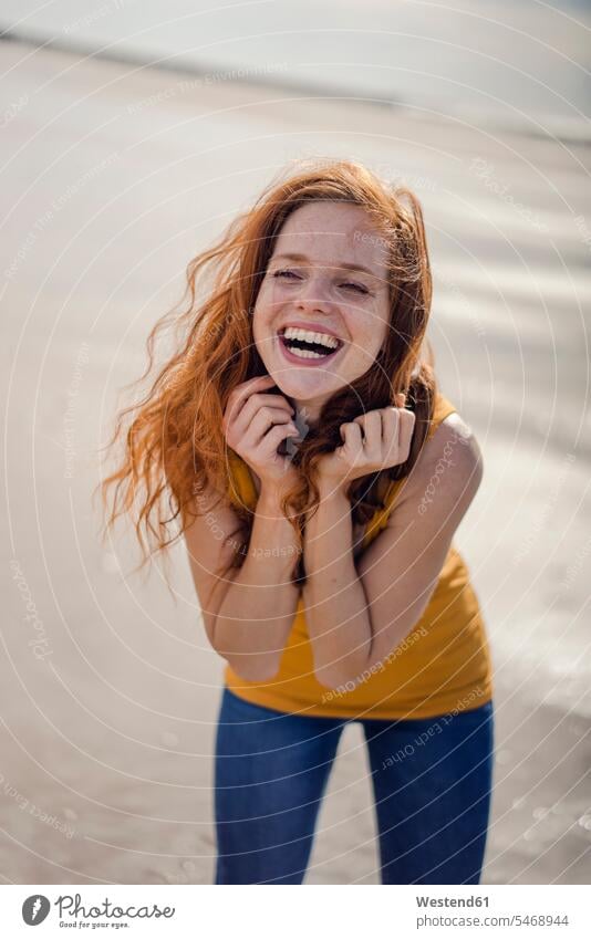 Redheaded woman, laughing happily on the beach caucasian caucasian ethnicity caucasian appearance european cheerful gaiety Joyous glad Cheerfulness exhilaration