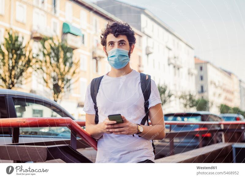 Young man wearing mask looking away while standing in city color image colour image leisure activity leisure activities free time leisure time casual clothing