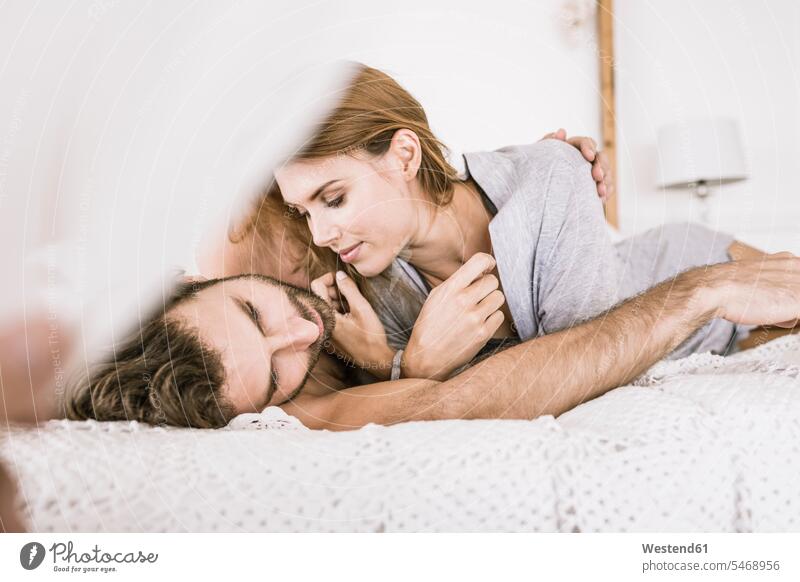 Affectionate young couple lying in bed Bed - Furniture beds relax relaxing cuddle snuggle snuggling embrace Embracement hug hugging relaxation enjoy enjoyment