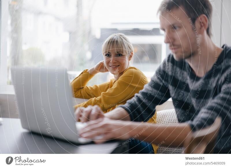 Man and woman sitting at table, using laptop using a laptop Using Laptops businesswoman businesswomen business woman business women Laptop Computers laptops