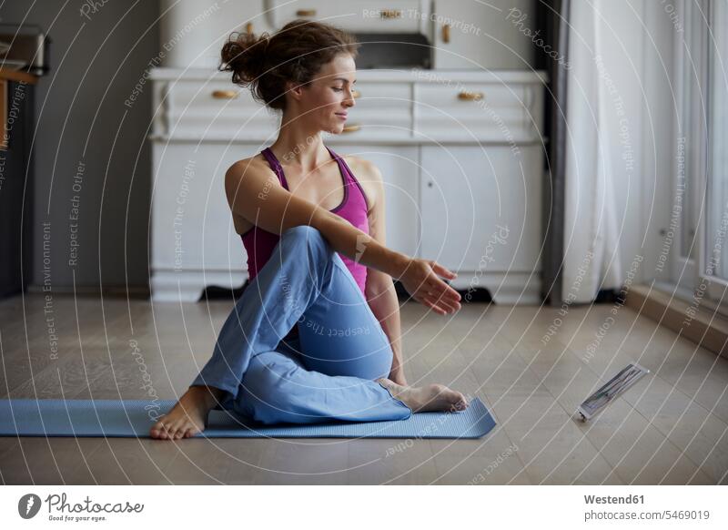 Woman watching digital tablet while practicing yoga at home color image colour image indoors indoor shot indoor shots interior interior view Interiors day