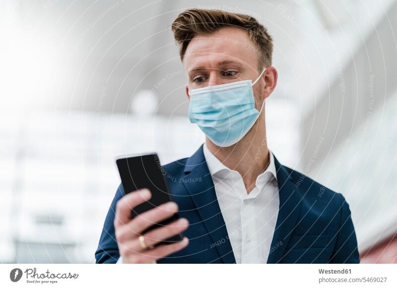 Businessman using mobile phone while wearing face mask in city color image colour image outdoors location shots outdoor shot outdoor shots day daylight shot