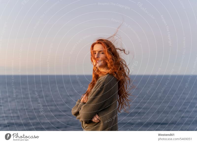 Portrait of redheaded young woman with windswept hair at the coast at sunset, Ibiza, Spain (value=0) human human being human beings humans person persons