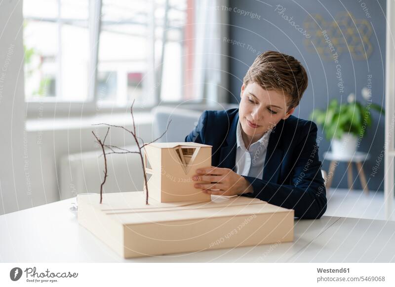Businesswoman working on architectural model in office human human being human beings humans person persons caucasian appearance caucasian ethnicity european 1