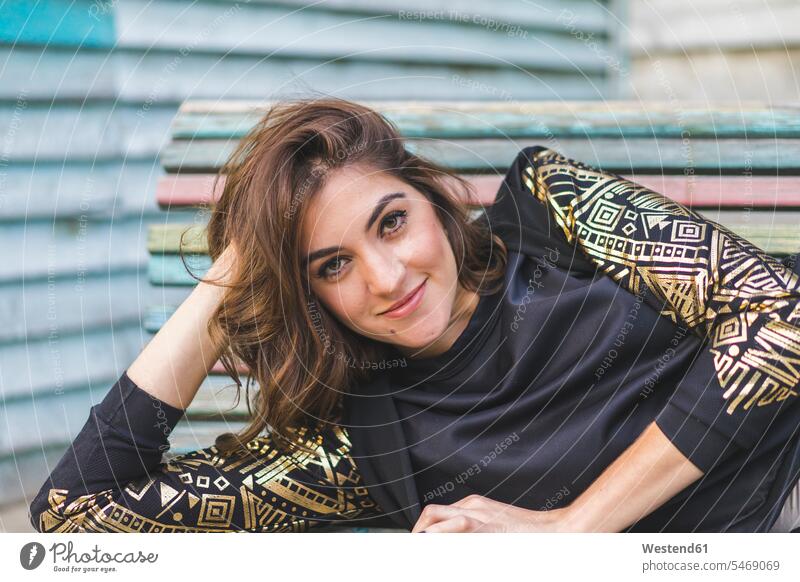 Portrait of fashionable young woman on a bench benches females women portrait portraits smiling smile Adults grown-ups grownups adult people persons human being