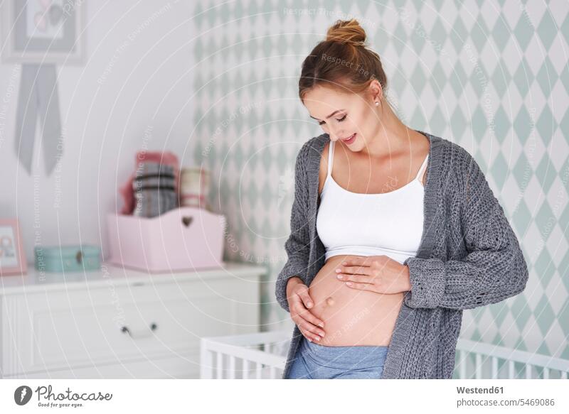 Pregnant woman stroking baby belly females women children's room Kids Room nursery child's room pregnant Pregnant Woman bellies abdomen human abdomen Adults