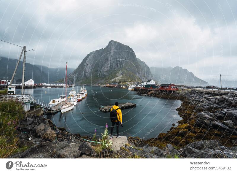 Norway, Lofoten, rear view of man standing at the coast men males coastline shoreline Adults grown-ups grownups adult people persons human being humans