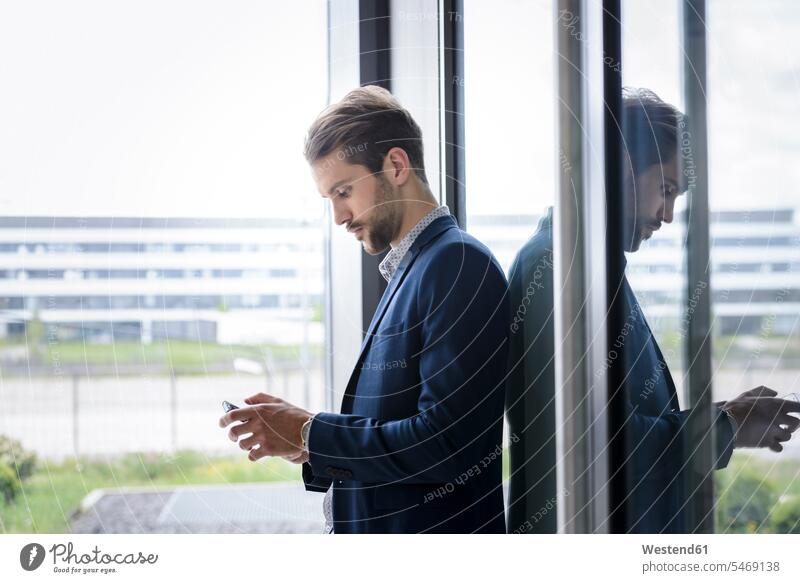 Young businessman using smartphone at the window human human being human beings humans person persons caucasian appearance caucasian ethnicity european 1