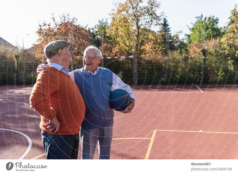 Two fit seniors having fun on a basketball field Basketball playing sportive sporting sporty athletic balls Best Friend Best Friends Best Pal laughing Laughter