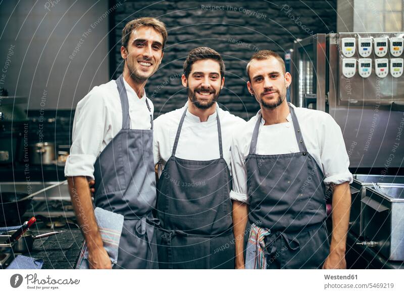 Portrait of three cooks in the kitchen of a restaurant colleague Occupation Work job jobs profession professional occupation Chefs At Work smile delight