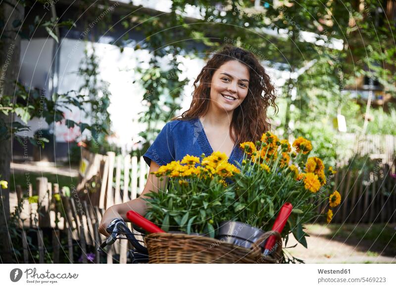 Young woman with flower pots in basket of bicycle baskets bikes bicycles bike - bicycle Cycle Cycle - Vehicle smile seasons summer time summertime summery