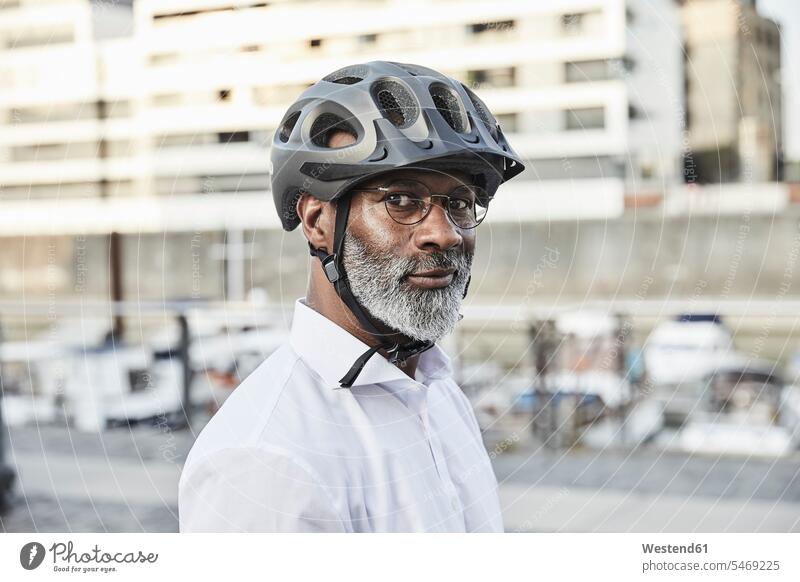 Portrait of mature businessman with grey beard wearing cycling helmet and glasses business life business world business person businesspeople Business man