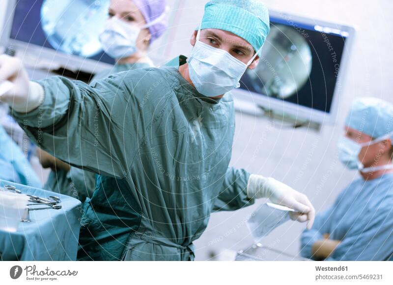 Surgical nurse at work during an operation working At Work surgery surgeries operating surgical nurse portrait portraits hospital Medical Clinic surgical gown