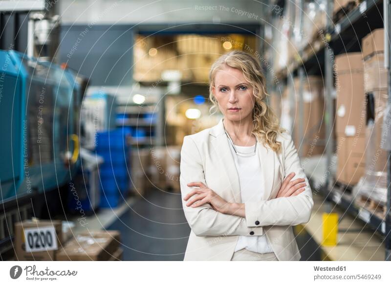 Portrait of confident woman in factory storehouse storage warehouse portrait portraits females women confidence factories dumps stock Adults grown-ups grownups