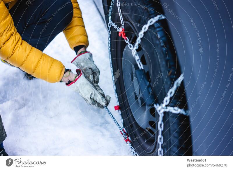 Man putting the snow chains on his car human human being human beings humans person persons caucasian appearance caucasian ethnicity european 1 one person only