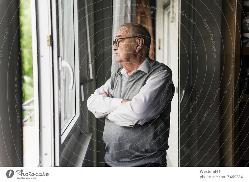Pensive senior man looking out of window human human being human beings humans person persons celibate celibates singles solitary people solitary person