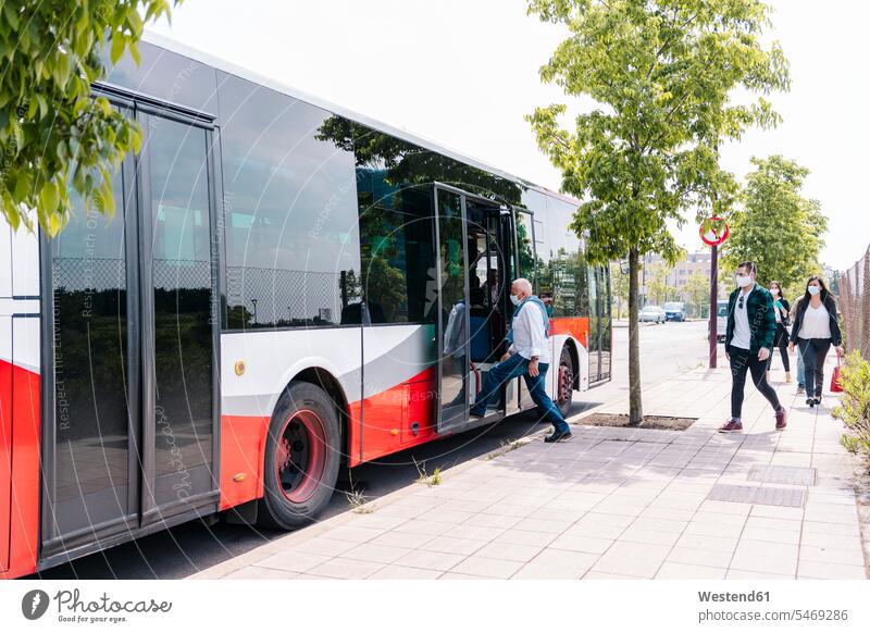 Passengers wearing protective masks getting into public bus, Spain transport motor vehicles road vehicle road vehicles buses busses travel traveling mobile