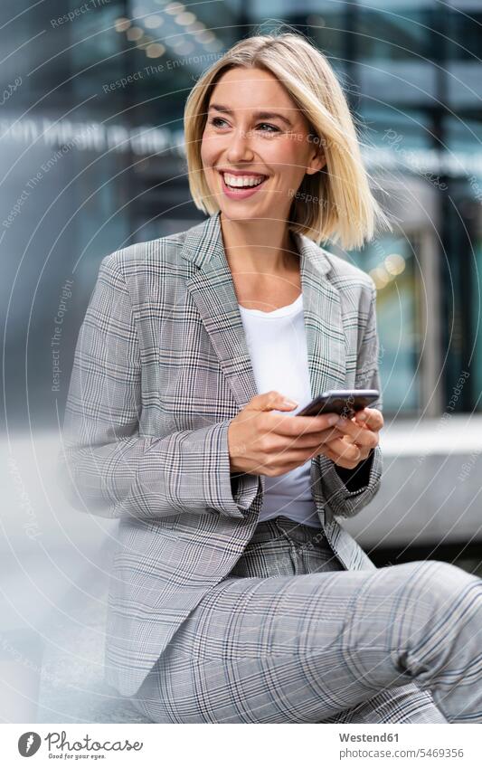 Happy young businesswoman with mobile phone in the city business life business world business person businesspeople business woman business women businesswomen