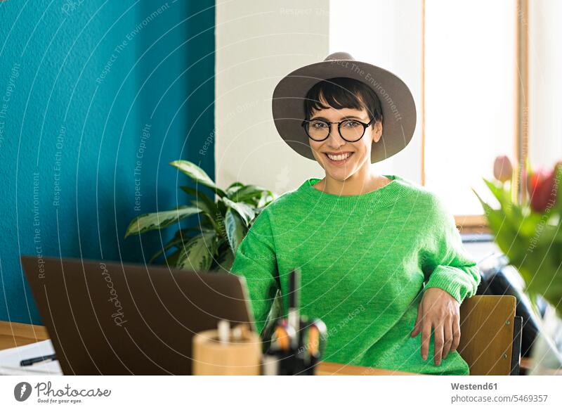 Portrait of happy businesswoman in home office working at her laptop portrait portraits businesswomen business woman business women apartment flats apartments