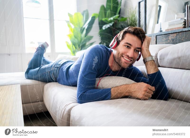 Relaxed man lying on couch listening to music human human being human beings humans person persons celibate celibates singles solitary people solitary person