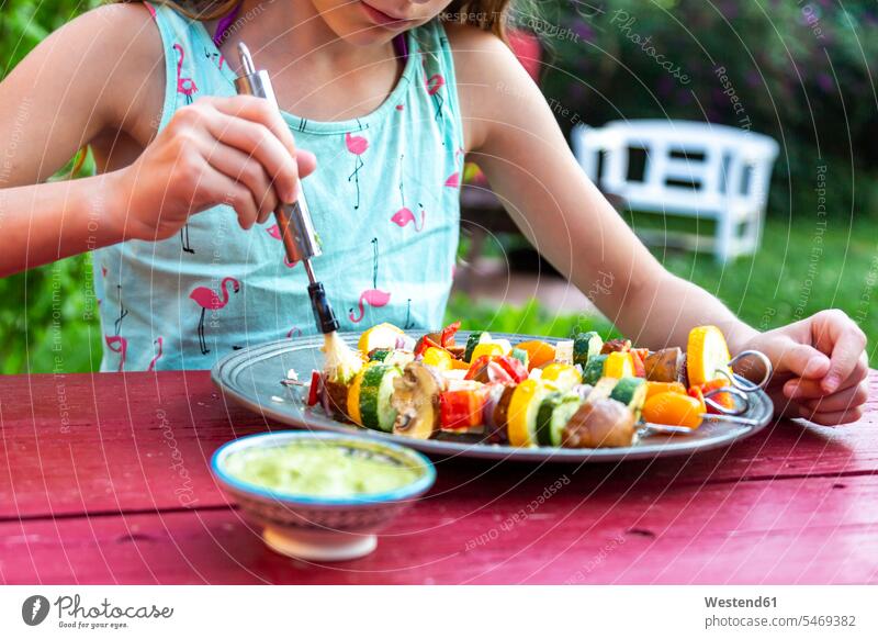 young girl spreading vegetarian grill skewers with Argentinian chimichurri grill spit grill spits preparing Food Preparation preparing food Vegetarian Food