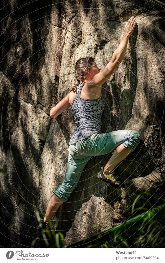 Female climber bouldering on rock, Avegno, Ticino, Switzerland grab grabbing grasp grasping grip free time leisure time Recreational Activities
