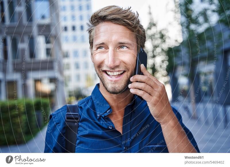Portrait of happy young businessman on the phone in the city business life business world business person businesspeople Business man Business men Businessmen
