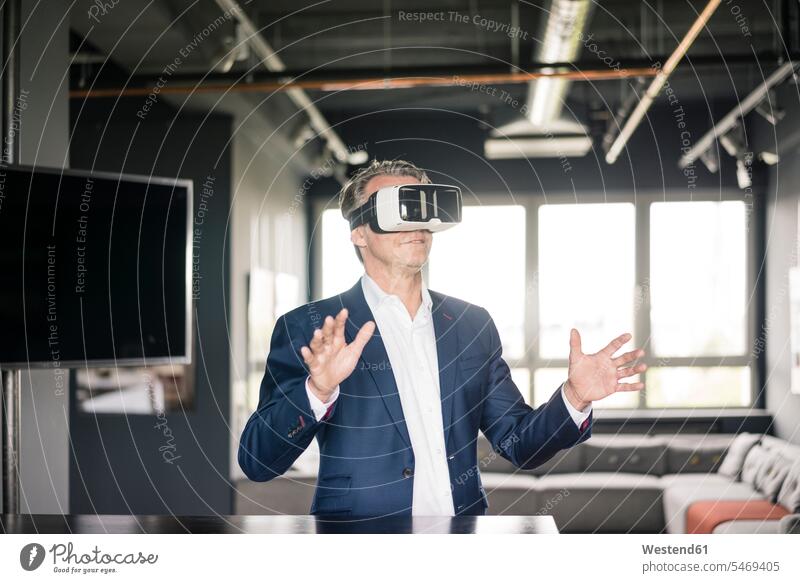 Mature businessman wearing VR glasses specs Eye Glasses spectacles Eyeglasses Businessman Business man Businessmen Business men virtual reality business people