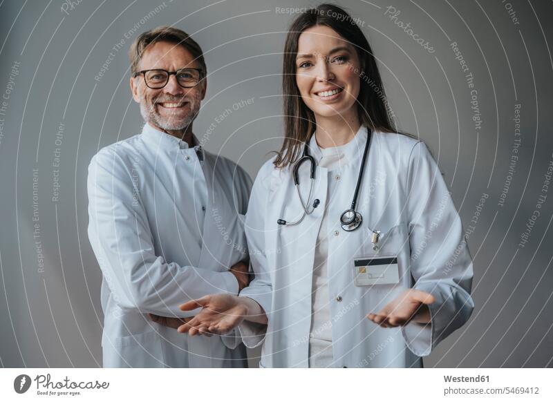 Smiling doctors standing against wall in hospital color image colour image indoors indoor shot indoor shots interior interior view Interiors science scientific