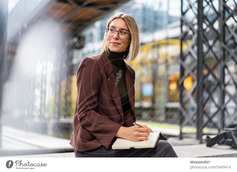 Smiling young businesswoman with notebook in the city human human being human beings humans person persons caucasian appearance caucasian ethnicity european 1