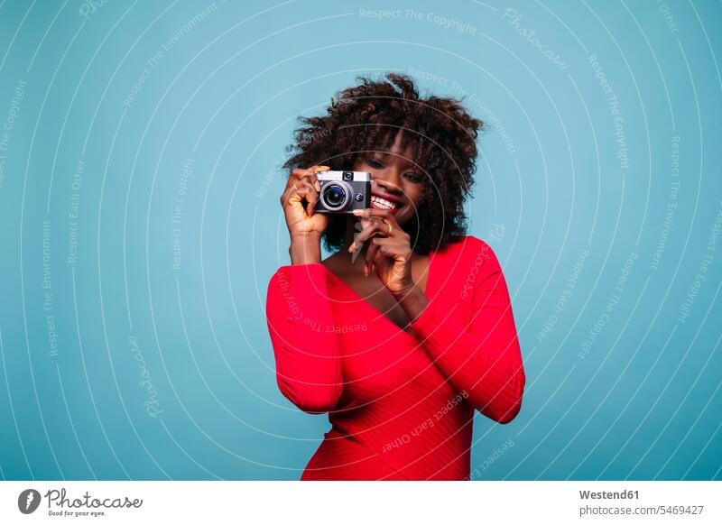 Portrait of happy young woman holding vintage camera in studio photographers human human being human beings humans person persons curl curled curls curly hair