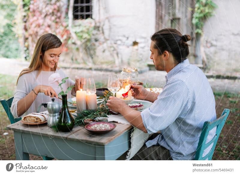 Couple having a romantic candlelight meal next to a cottage Meals couple twosomes partnership couples Cottage candle light eating lyrical Romance Food foods