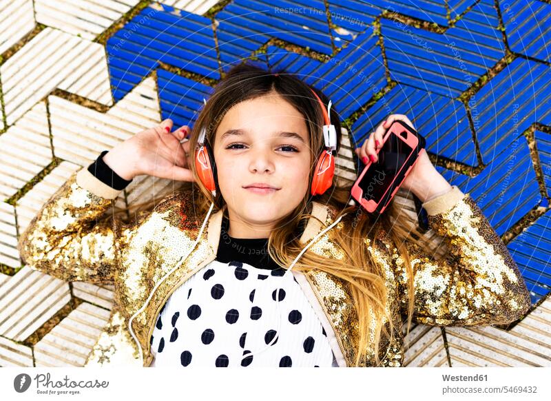 Portrait of girl wearing golden sequin jacket listening music with headphones and smartphone coat coats jackets headset portrait portraits Smartphone iPhone