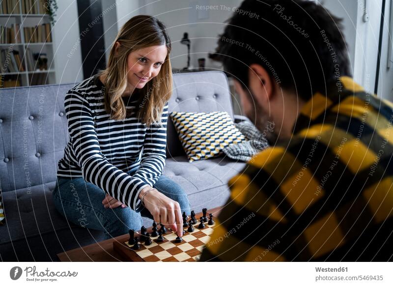 Woman and man playing chess at home indoors indoor shot indoor shots interior interior view Interiors day daylight shot daylight shots day shots daytime sitting