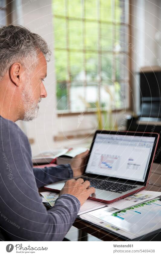 Mature man working in his home office at a loft apartment lofts working from home home business laptop Laptop Computers laptops notebook At Work mature men