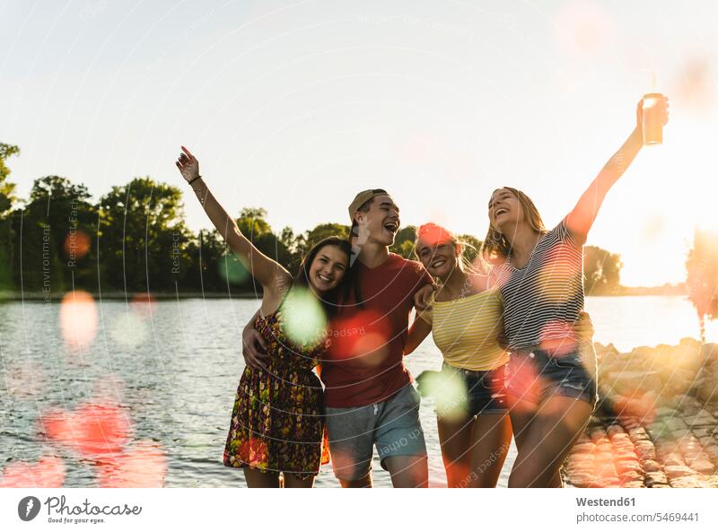 Group of happy friends having fun in a river at sunset happiness Fun funny River Rivers sunsets sundown group of people groups of people mate water waters