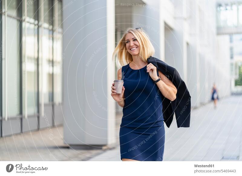 Portrait of smiling blond businesswoman with coffee to go wearing blue summer dress business life business world business person businesspeople business woman
