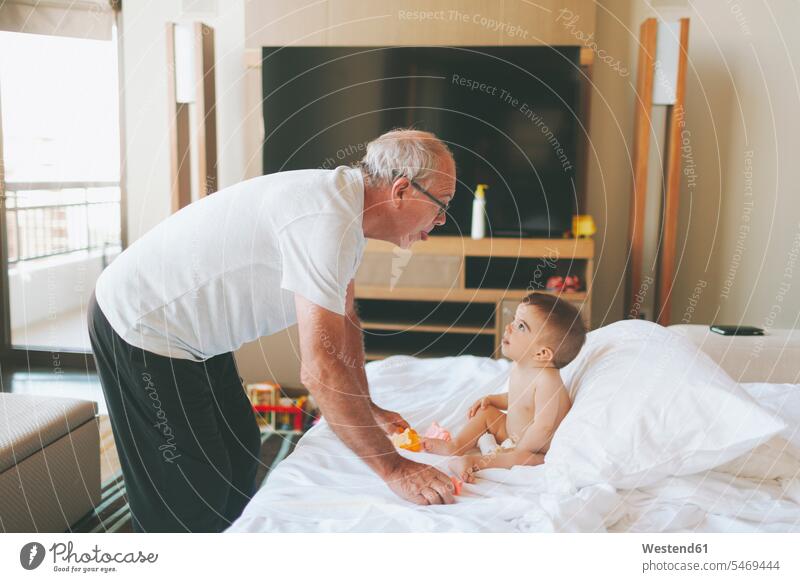 Grandfather playing with a baby at home sticking out tongue human human being human beings humans person persons caucasian appearance caucasian ethnicity