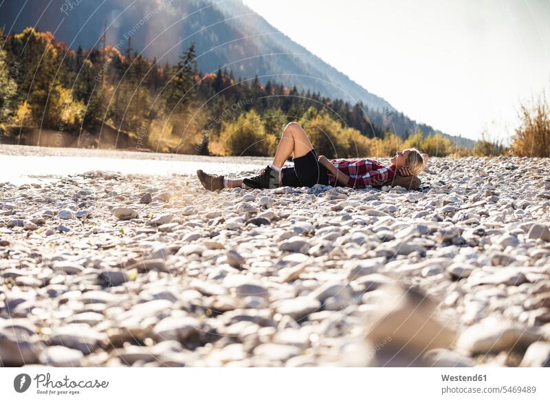 Austria, Alps, woman on a hiking trip having a break lying at a brook caucasian caucasian appearance caucasian ethnicity european White - Caucasian mature woman