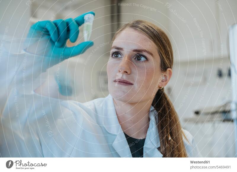 Young woman examining test tube while standing at laboratory color image colour image indoors indoor shot indoor shots interior interior view Interiors day