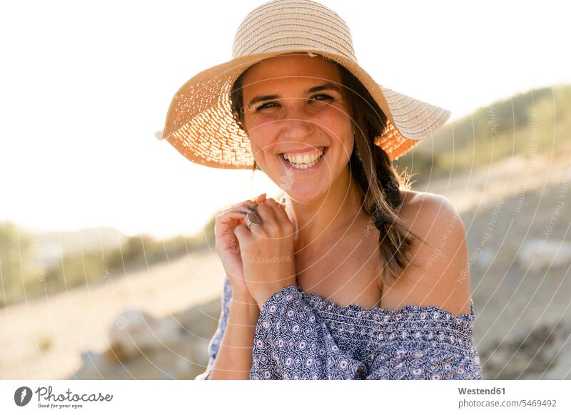 Happy young woman wearing sun hat during sunny day color image colour image outdoors location shots outdoor shot outdoor shots daylight shot daylight shots