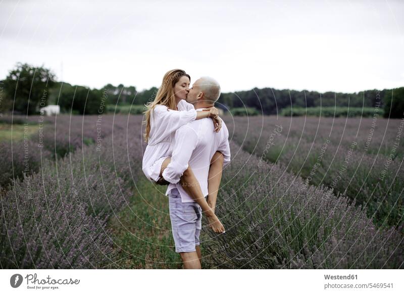 Couple in love on lavender field shirts dresses relaxing hold delight enjoyment Pleasant pleasure indulgence indulging savoring happy emotional Emotions Feeling