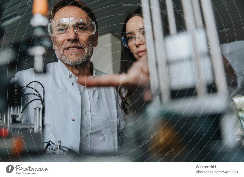 Close-up of scientists with protective eyewear examining machine in laboratory color image colour image indoors indoor shot indoor shots interior interior view