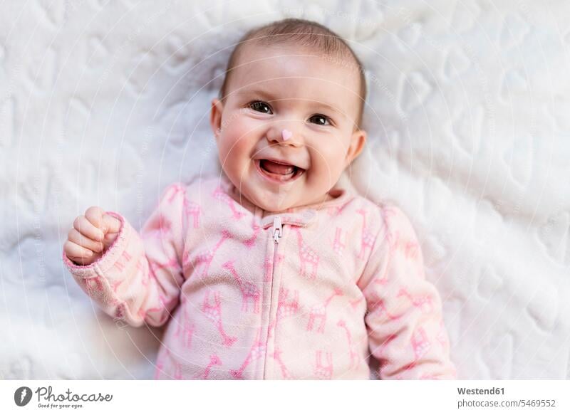 Portrait of laughing baby girl with pink heart-shaped candy on nose human human being human beings humans person persons caucasian appearance