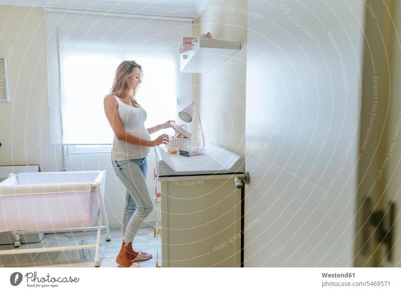 Pregnant woman preparing the baby room baby's room females women pregnant Pregnant Woman rooms domestic room domestic rooms Adults grown-ups grownups adult
