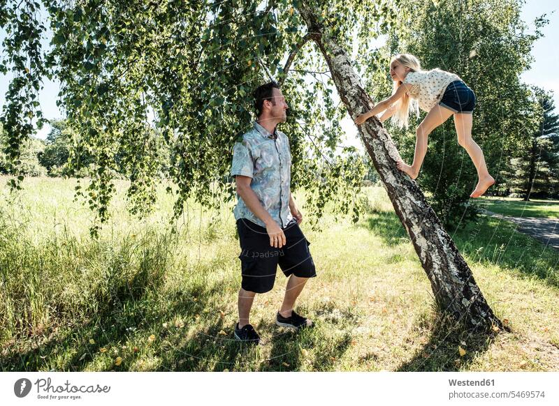 Father watching daughter climbing a birch trunk in park human human being human beings humans person persons caucasian appearance caucasian ethnicity european