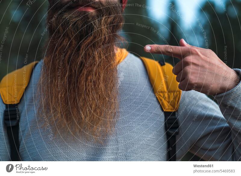 Close-up of man wearing backpack pointing at his beard men males rucksacks backpacks back-packs point at Adults grown-ups grownups adult people persons